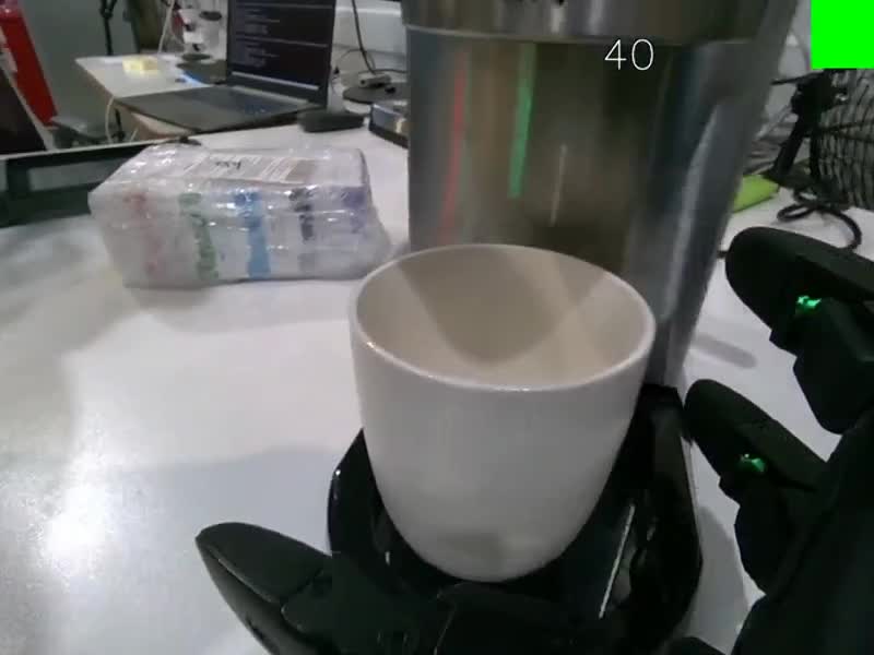 A dexterous three-fingered robot hand grasping a cup